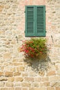 Brick wall, window with wooden blind and flower