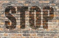 Brick wall with the word Stop written in 3D.