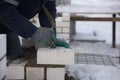 A bricklayer aligns bricks in cement, makes a concrete wall. Royalty Free Stock Photo