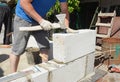 Bricklayer builder laying autoclaved aerated concrete blocks, aac for new house wall