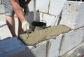 Bricklayer builder laying autoclaved aerated concrete blocks, aac.  Autoclaved aerated concrete blocks walling installation with Royalty Free Stock Photo