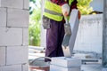 Bricklayer builder using cement mortar to put the Lightweight bricks. at construction site