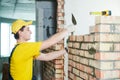 Bricklayer builder worker laying bricks wall