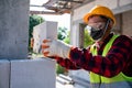 Bricklayer builder working with autoclaved aerated concrete blocks. Walling, installing bricks on construction site Royalty Free Stock Photo