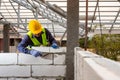 Bricklayer builder working with autoclaved aerated concrete blocks. Walling, installing bricks on construction site, Engineering Royalty Free Stock Photo