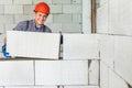 Bricklayer builder working with autoclaved aerated concrete blocks. Walling, installing bricks on construction site. Engineering Royalty Free Stock Photo
