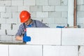 Bricklayer builder working with autoclaved aerated concrete blocks. Walling, installing bricks on construction site. Engineering Royalty Free Stock Photo