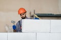 bricklayer builder working with autoclaved aerated concrete blocks. Walling, installing bricks on construction site Royalty Free Stock Photo