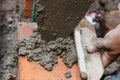 Bricklayer building a house using tools and cement