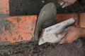 Bricklayer building a house using tools and cement