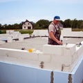 Bricklayer building wall from aerated concrete blocks