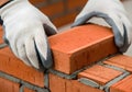 Bricklayer carefully placing a brick on a wall under construction Royalty Free Stock Photo