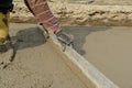 Bricklayer on construction site with straightedge - concrete
