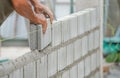 Bricklayer hands installing brick block on construction site Royalty Free Stock Photo