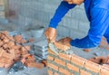 Bricklayer industrial worker installing brick masonry with trowel putty knife Royalty Free Stock Photo