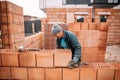 Bricklayer industrial worker installing new bricks. masonry on exterior wall Royalty Free Stock Photo