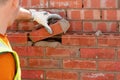 Bricklayer laying bricks on mortar on new residential house construction, Last brick to fill the gap