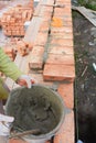 Bricklayer laying house brick wall from red bricks. Masonry Royalty Free Stock Photo