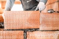 Bricklayer construction worker installing interior brick masonry