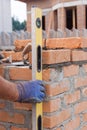 Bricklayer Using a building level to Check New Red Brick Wall Outdoor. Bricklaying Basics Masonry Techniques. Royalty Free Stock Photo