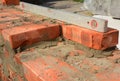 Bricklayer Using a Spirit Level to Check Bricklaying Wall Outdoors. Bricklaying Basics Masonry Techniques