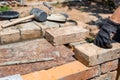 Bricklayer in a work glove laying bricks with mortar on a construction site. house building, manual labor, professional Royalty Free Stock Photo