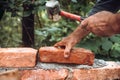 Construction bricklayer worker building with bricks, mortar, trowel and rubber hammer