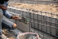 Bricklayer worker installing brick masonry on exterior wall