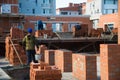 Bricklayer worker installing brick masonry on exterior wall