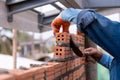 Bricklayer worker installing brick masonry exterior wall with trowel putty knife on construction site Royalty Free Stock Photo