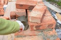 Bricklayer Worker Installing Red Blocks and Caulking Brick Masonry Joints Exterior Wall with Trowel putty Knife. Bricklaying Mason Royalty Free Stock Photo