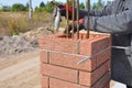 Bricklayer Worker Installing Red Clinker Blocks around Iron Bar Royalty Free Stock Photo
