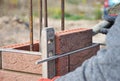 Bricklayer Worker Installing Red Clinker Blocks and Caulking Brick Masonry Joints Exterior Wall with Trowel putty Knife