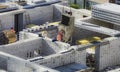 Bricklayer worker in safety orange vest and hard hat make walls of white silicate bricks on a construction site of a big Royalty Free Stock Photo