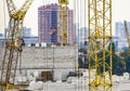 Bricklayer workers in safety orange vests and hard hats make walls of white silicate bricks on a construction site of a big Royalty Free Stock Photo