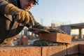 Bricklayer working on a construction site, laying bricks with mortar Royalty Free Stock Photo