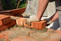 Bricklayers hands in masonry gloves bricklaying new house wall. Bricklaying house wall Royalty Free Stock Photo