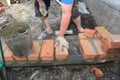 Bricklayers hands in masonry gloves bricklaying  new house wall on foundation Royalty Free Stock Photo