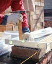 Bricklayers hands with in masonry trowel bricklaying new house wall on foundation. Close up of industrial bricklayer installing Royalty Free Stock Photo