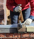 Bricklayers hands with in masonry trowel bricklaying new house wall on foundation. Close up of industrial bricklayer installing