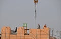 Masons laying bricks standing high on scaffolding