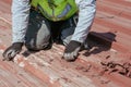 Bricklayers scraping the waterproofing off a roof with a trowel to prevent dampness in the buildings