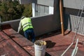 Bricklayers scraping the waterproofing off a roof with a trowel to prevent dampness in the buildings Royalty Free Stock Photo