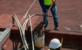 Bricklayers scraping the waterproofing off a roof with a trowel to prevent dampness in the buildings Royalty Free Stock Photo