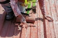 Bricklayers scraping the waterproofing off a roof with a trowel to prevent dampness in the buildings