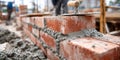 Bricklayers work on a construction site, focusing on laying bricks and applying mortar at a building project in Royalty Free Stock Photo