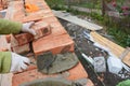 Bricklaying. Bricklayer worker installing red blocks and caulking brick masonry joints exterior brick house wall with trowel putt