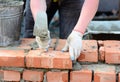 Bricklaying: builder building a brick masonry wall with brick trowel. Masonry Wall Construction