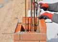 Bricklaying Closeup. Bricklayer hand holding a Putty Knife and Building a Brick Wall Column