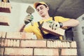 Bricklayer builder worker laying bricks wall